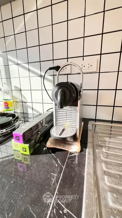 Modern kitchen with sleek coffee machine and tiled backsplash