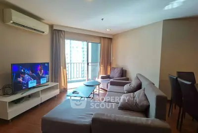 Spacious living room with modern furniture and balcony view in urban apartment.