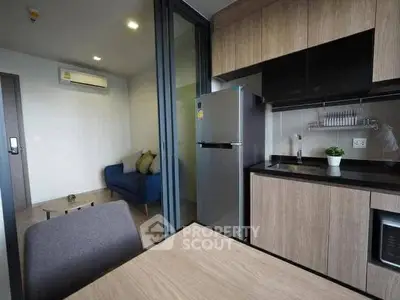Modern open-layout kitchen with sleek appliances and cozy living area