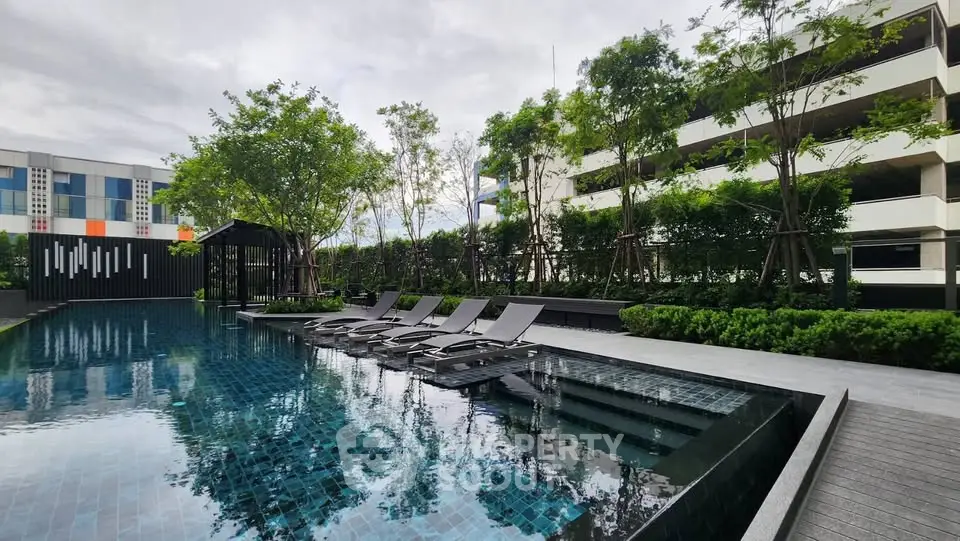 Luxurious outdoor pool area with modern design and lush greenery in a high-end residential complex.