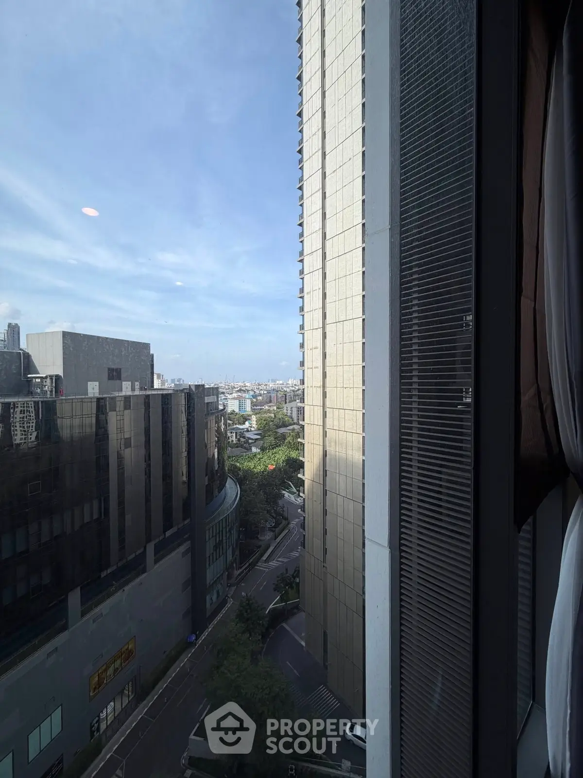 Stunning urban view from high-rise building window showcasing cityscape and skyline.