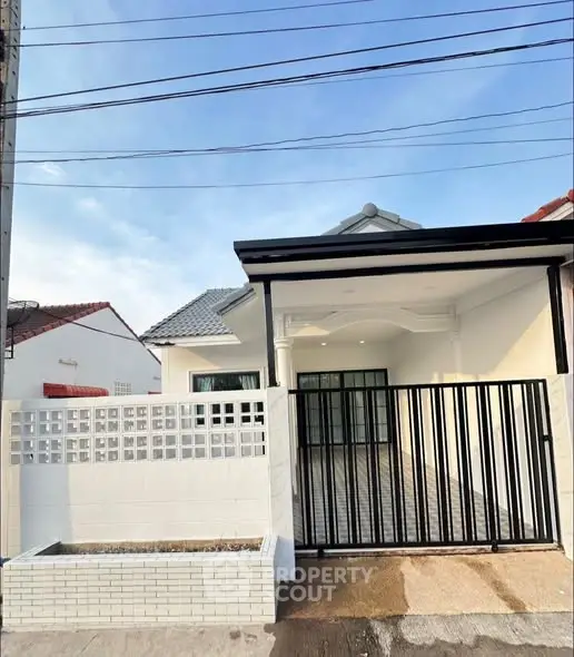 Charming single-story home with modern facade and gated entrance, perfect for family living.