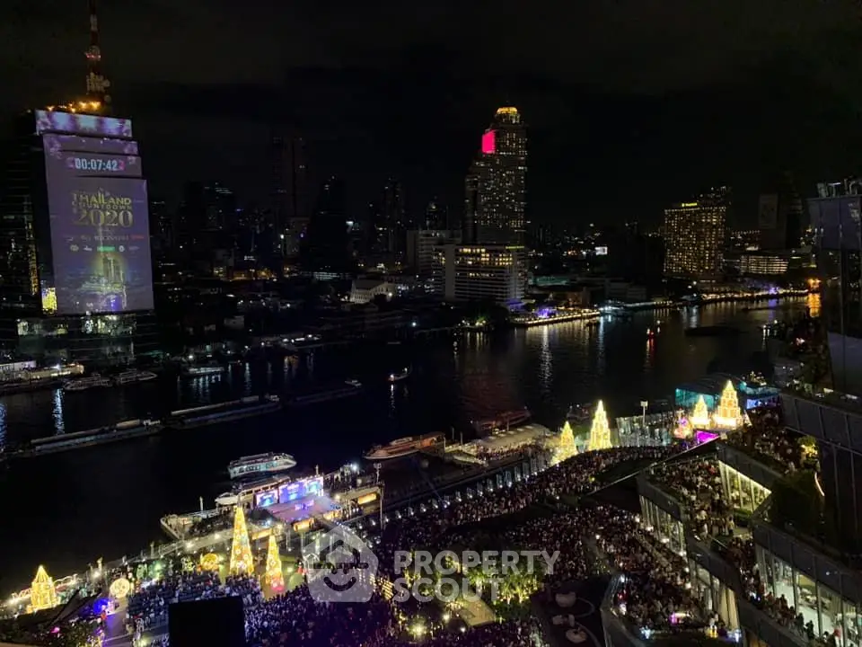 Stunning night view of city skyline and river with festive lights and vibrant atmosphere.