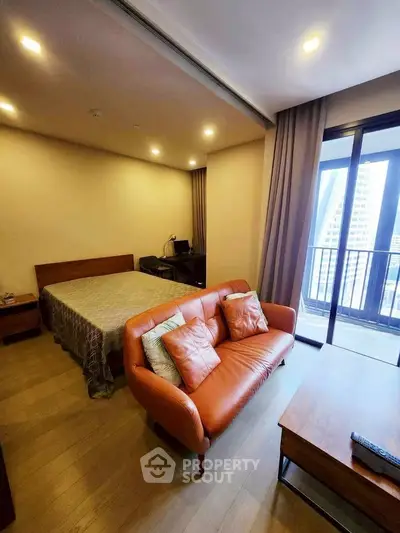 Modern studio apartment with cozy living area and balcony view