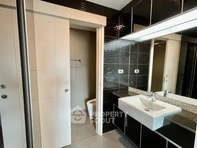 Modern bathroom with sleek black tiles and stylish white fixtures