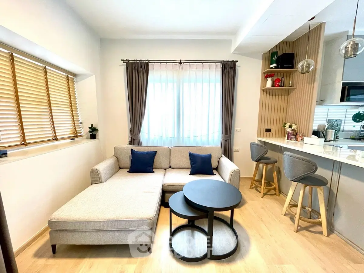 Modern living room with stylish furniture and open kitchen layout, perfect for cozy gatherings.