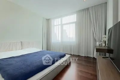 Spacious modern bedroom with large window and elegant decor
