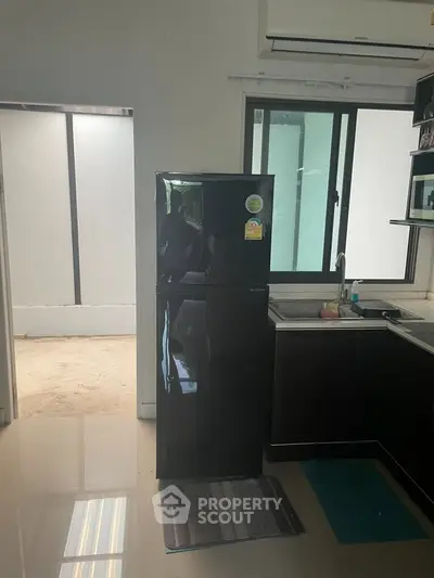 Modern kitchen with sleek black refrigerator and minimalist design