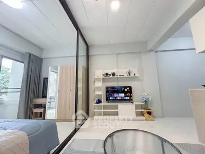 Modern living room with sleek design, featuring a TV, stylish shelving, and a cozy seating area.