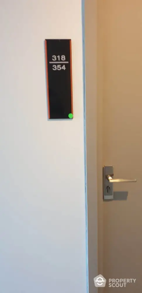 Modern apartment hallway with room number signage and sleek door handle