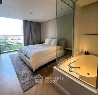 Luxurious bedroom with modern bathtub and large window offering scenic views.