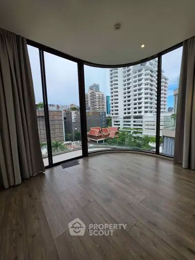 Spacious corner unit with floor-to-ceiling windows offering a stunning city view, perfect for urban living.
