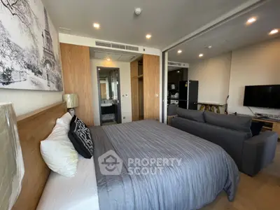 Modern bedroom with stylish decor and open living area in a contemporary apartment.