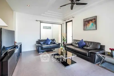 Modern living room with sleek black leather sofas and stylish decor