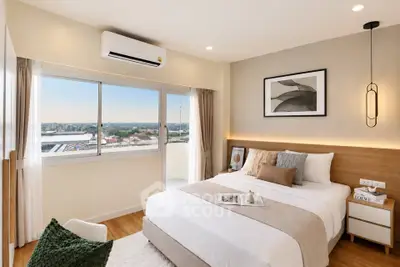 Modern bedroom with large window and stylish decor offering a stunning city view.