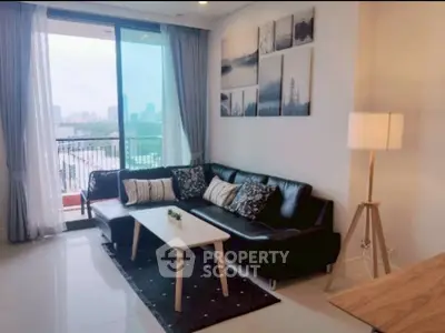 Modern living room with city view, stylish decor, and cozy seating area.