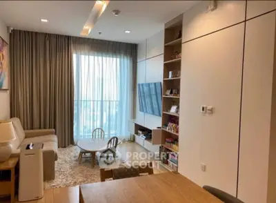 Modern living room with large window, cozy seating, and stylish decor in a contemporary apartment.