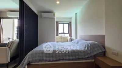 Cozy bedroom with modern decor and natural light in a stylish apartment.