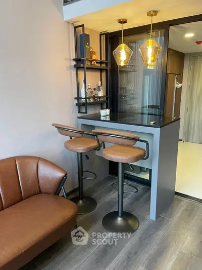 Stylish modern home bar with leather stools and elegant lighting in a cozy living space.
