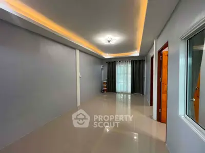 Spacious modern living room with sleek lighting and large window for natural light.