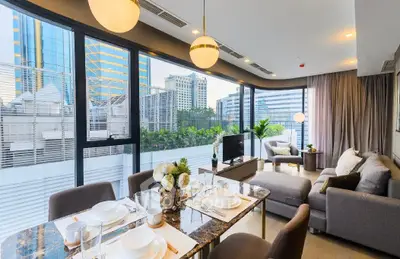 Luxurious modern living room with city view, elegant decor, and spacious seating area in high-rise apartment.