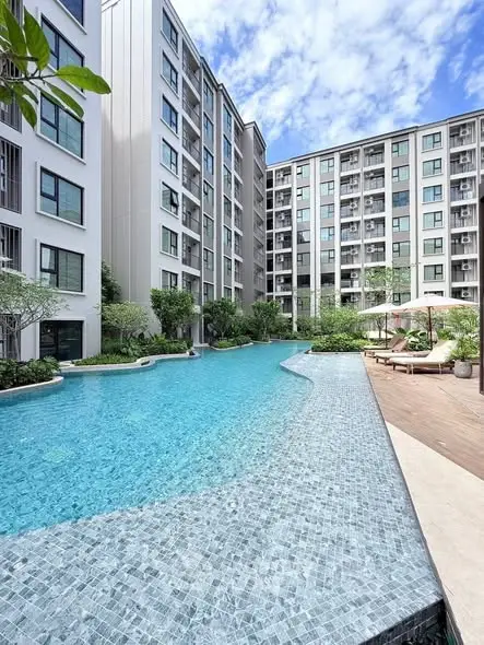 Luxurious apartment complex with a stunning outdoor pool and modern architecture.