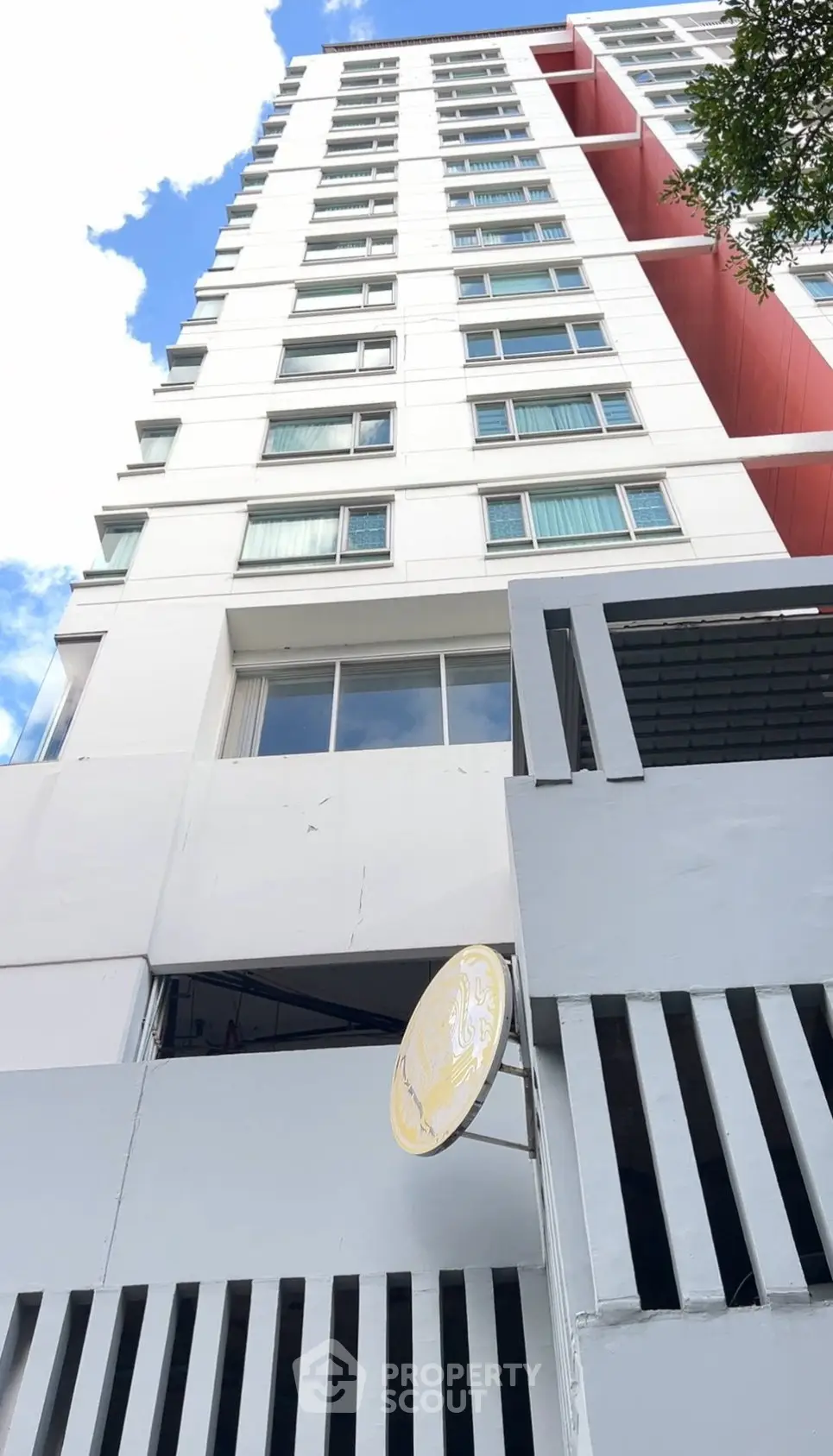 Modern high-rise building with sleek facade and blue sky backdrop.