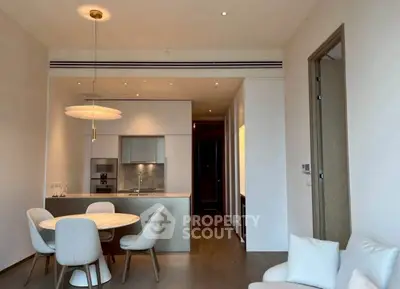 Modern open-plan kitchen and dining area with sleek design and cozy seating.