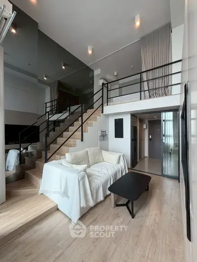 Modern duplex living room with stylish staircase and cozy seating area