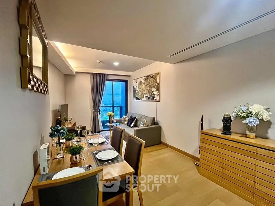 Elegant living room with dining area, stylish decor, and large window offering natural light.