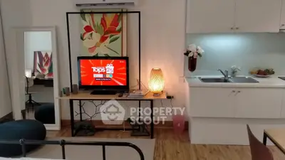 Charming studio apartment with modern decor and cozy living area, featuring a sleek kitchenette and stylish furnishings.