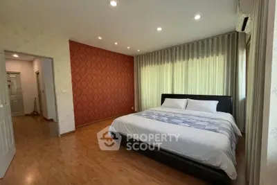 Spacious bedroom with elegant decor and large windows for natural light