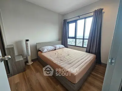 Modern bedroom with large window and wooden flooring