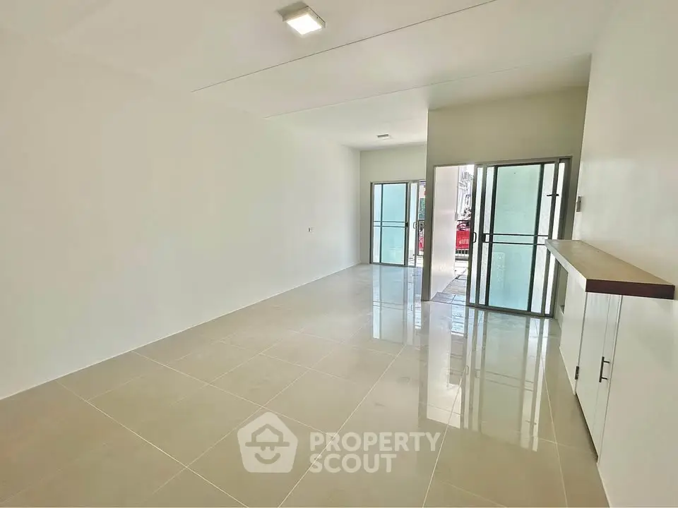 Spacious modern living room with sleek tile flooring and ample natural light