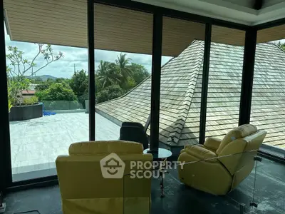 Luxurious living room with panoramic views and modern design in a tropical setting.