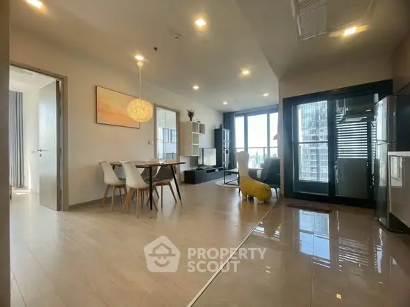 Spacious modern living room with dining area and large windows offering city views.