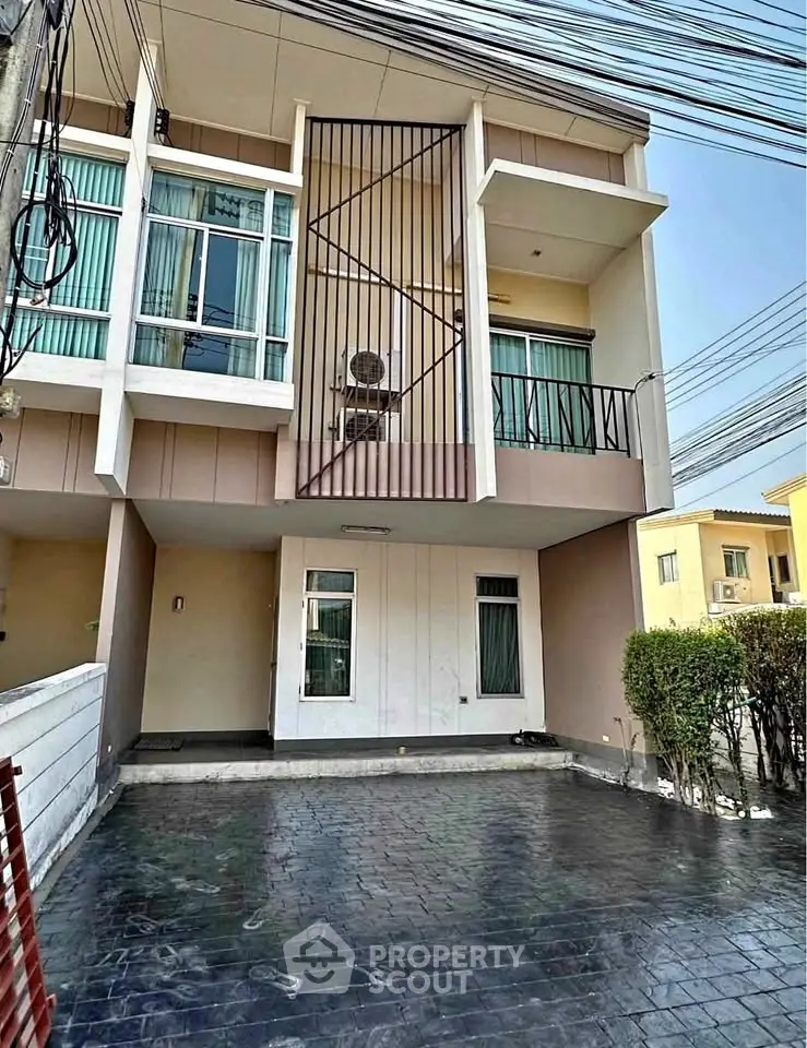 Modern townhouse exterior with spacious driveway and balcony