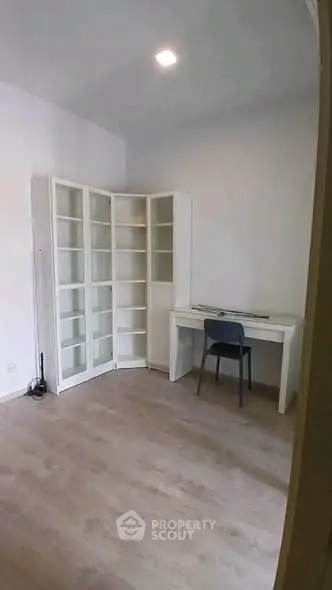Spacious study room with modern desk and shelving, perfect for productivity.