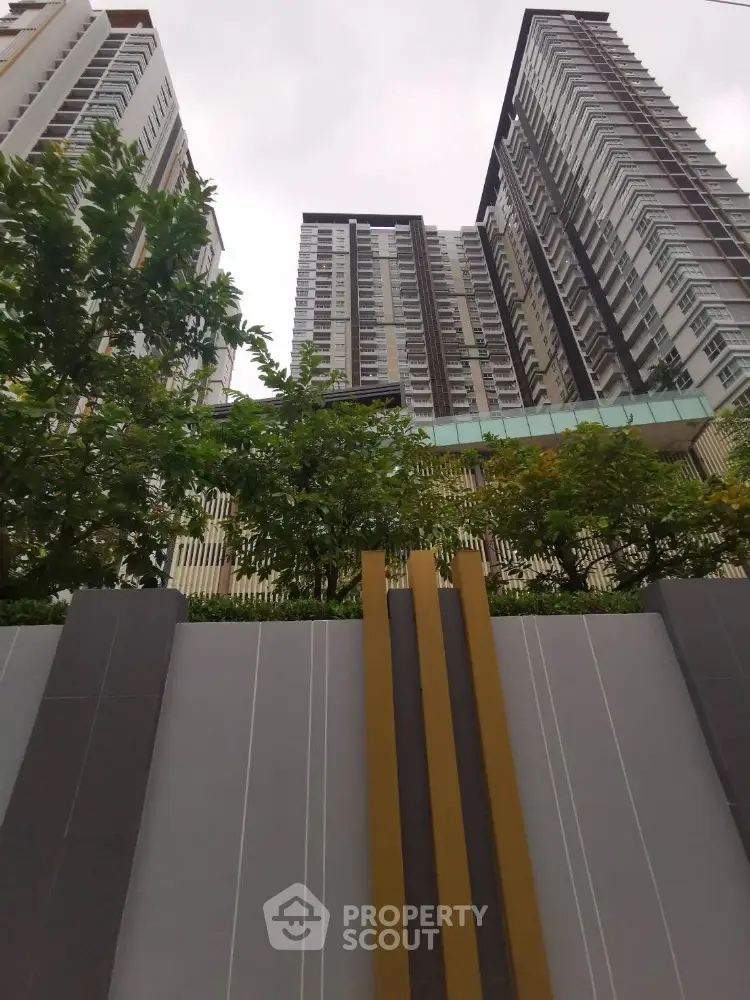 Modern high-rise residential building with lush greenery and stylish facade