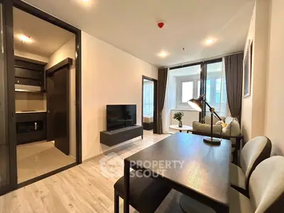 Modern living room with open layout and stylish furniture, featuring a cozy dining area and natural light.