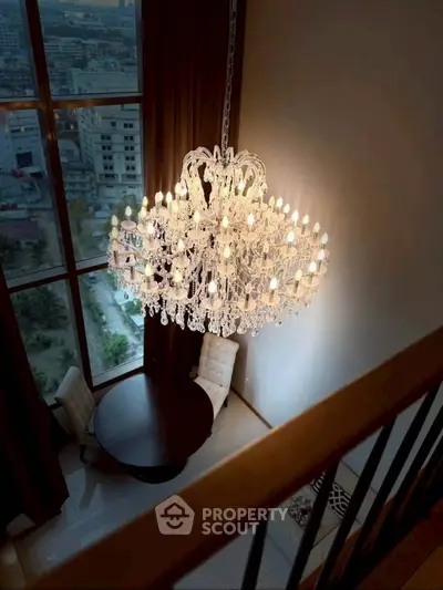 Luxurious high-ceiling living room with grand chandelier and city view.