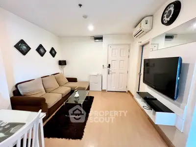 Modern living room with cozy sofa, wall-mounted TV, and stylish decor in a well-lit apartment.