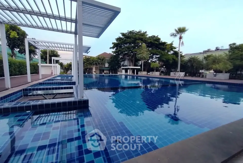Luxurious outdoor pool with modern design and lush greenery, perfect for relaxation and leisure.