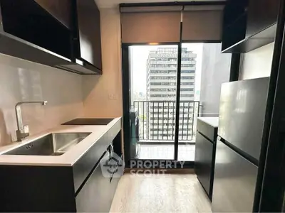 Modern kitchen with sleek black cabinets and city view balcony access.