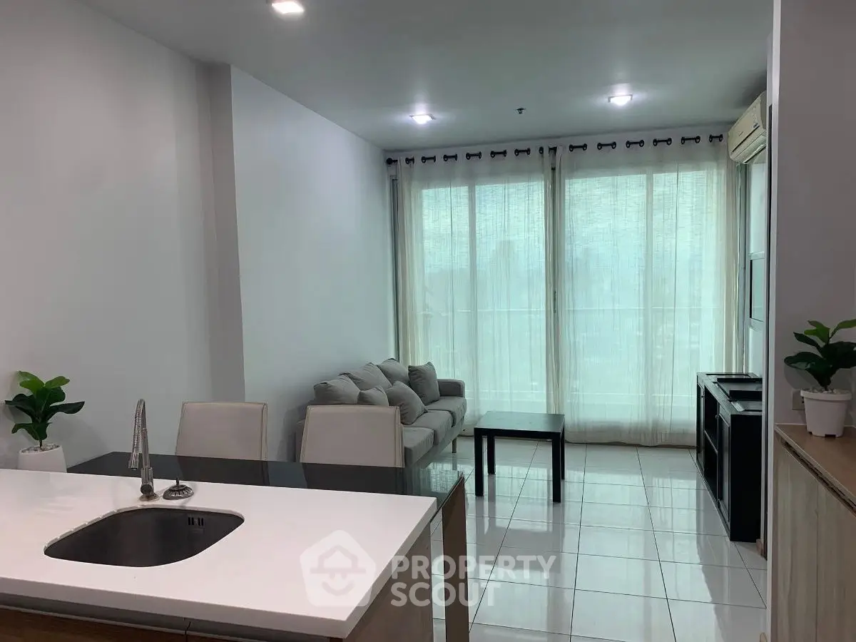 Modern open-layout living room with kitchen island and large windows