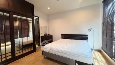 Spacious bedroom with large windows and modern furnishings