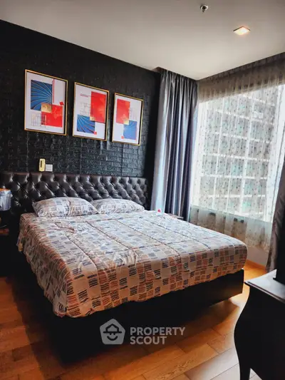 Luxurious bedroom with modern decor and large window offering city views