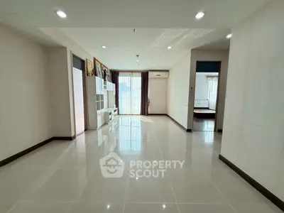 Spacious modern living room with glossy tiled floors and natural light