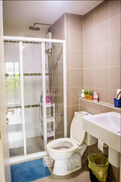 Modern bathroom with glass shower enclosure and sleek fixtures in a contemporary apartment.
