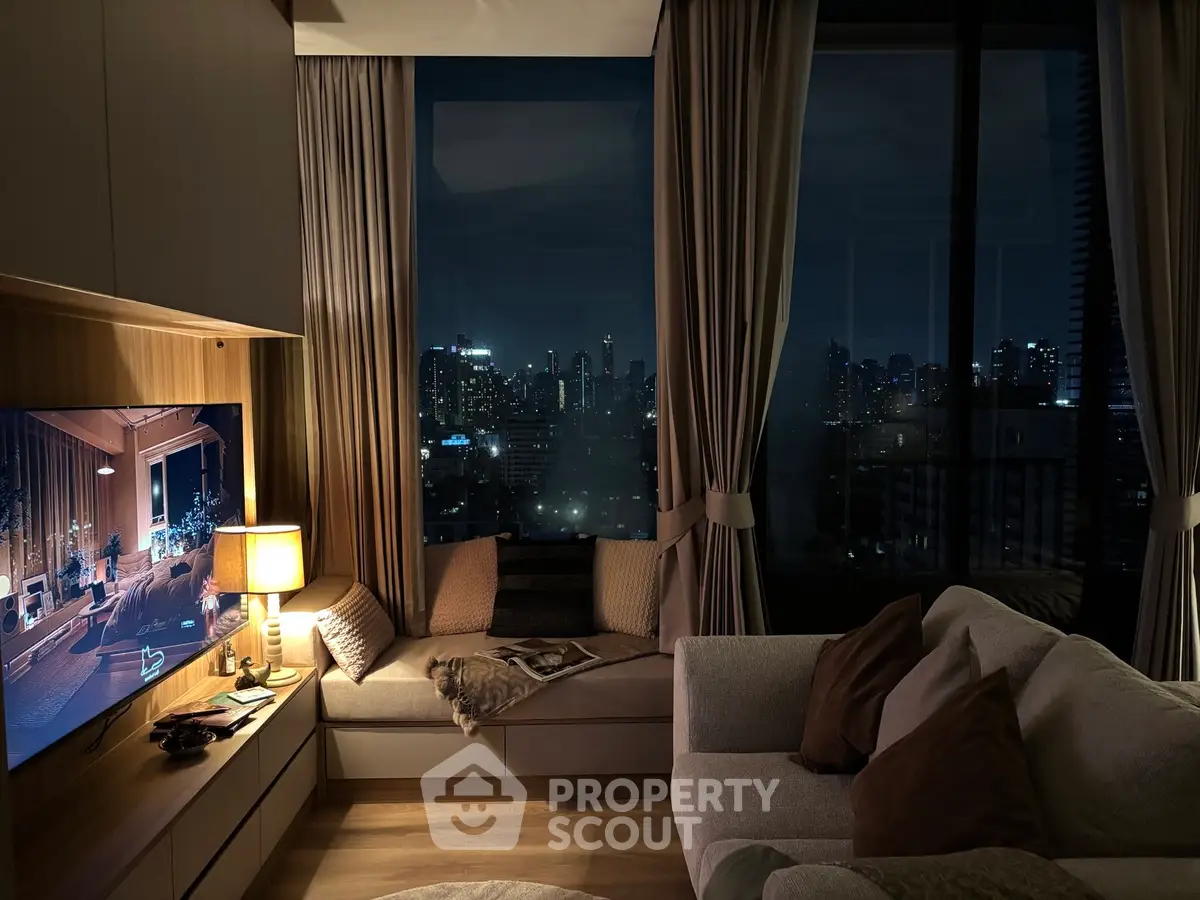 Luxurious living room with stunning city skyline view at night, cozy seating, and ambient lighting.